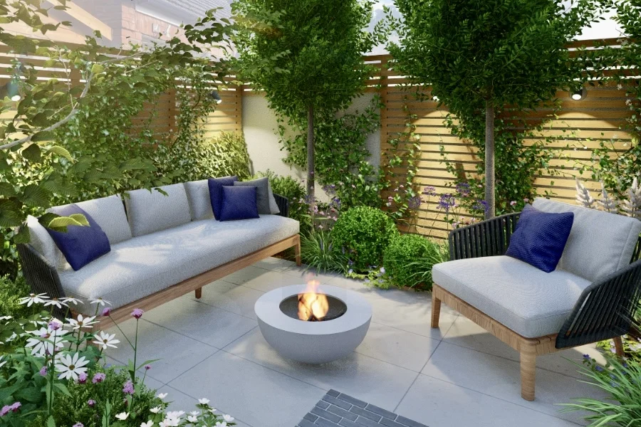 idées d'aménagement d'une petite cour dans un jardin en ville - APRES : un joli coin salon avec un fauteuil, un canapé, des coussins, un brasero au mileu et un éclairage d'ambiance
