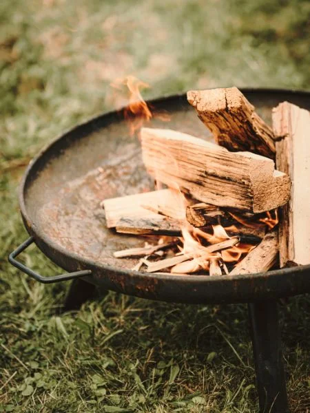 Un brasero improvisé dans un plateau en métal - des bûches de bois qui commencent à s'enflammer